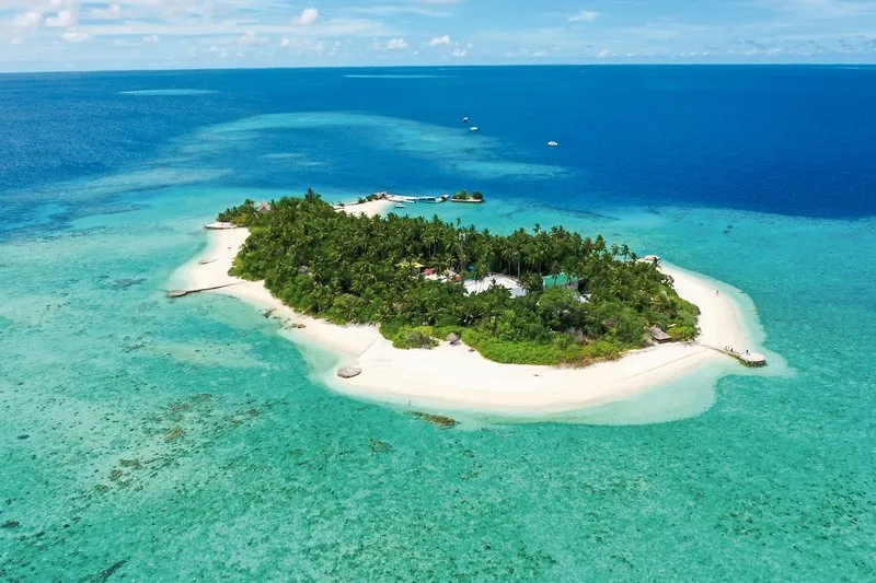 Zračni posnetek otoka Makunudu s turkizno laguno in peščeno plažo